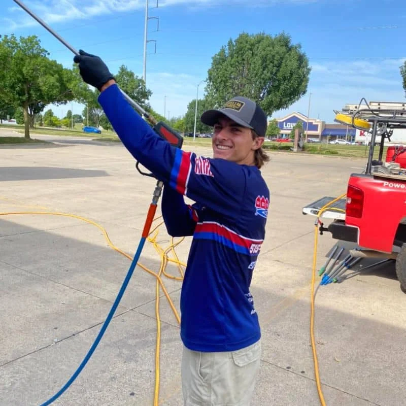 American Softwash technician holding pressure-washing equipment