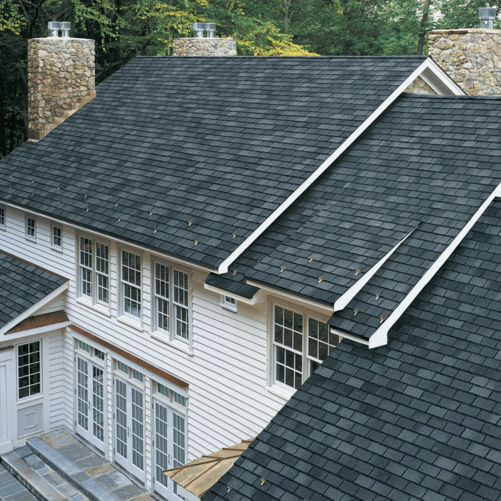 Clean dark-shingle roof on a large home